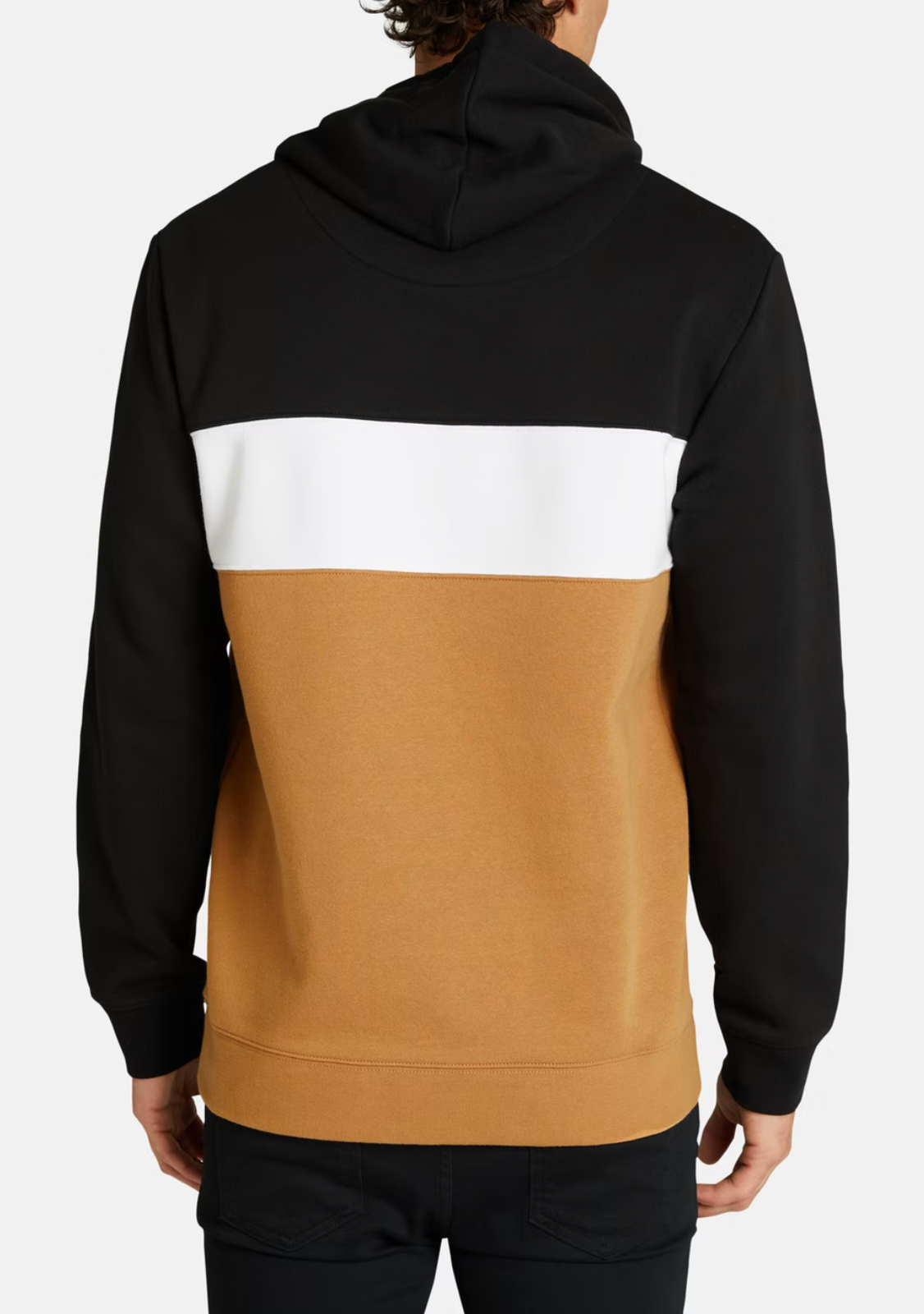A person seen from behind wearing the Connor Downtown Sweat, featuring black top and sleeves, a white horizontal back stripe, a tan bottom section, and black pants—a cozy fleece-lined choice for casual street style.