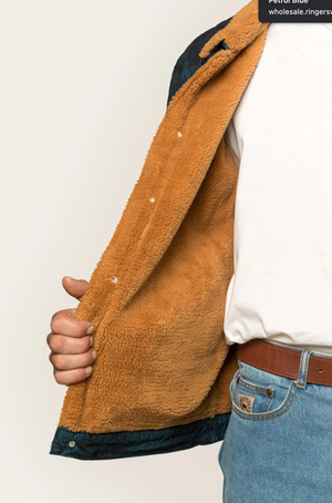 A person wearing blue jeans, a white t-shirt, and a brown leather belt is holding open the Ringers Western Milawa Corduroy Jacket with its soft, fuzzy brown lining, revealing the comfortable interior. The person's face is not visible in the image.