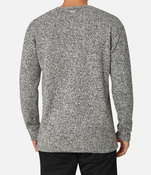 A person wearing the Industrie The Hacienda Knit, a regular fit crew neck gray speckled sweater, paired with black pants, stands with their back to the camera.