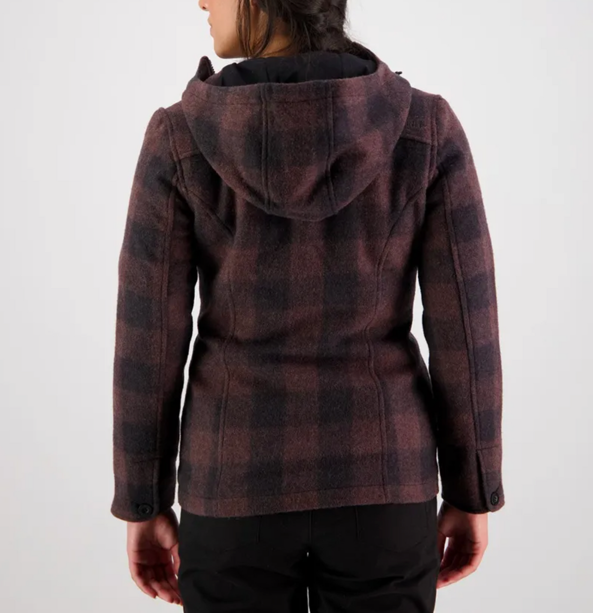 A person with dark hair is seen from the back, wearing a Swanndri Womens Seattle Hoody, crafted from New Zealand wool in muted shades of red and gray. The image is set against a plain, light-colored background.