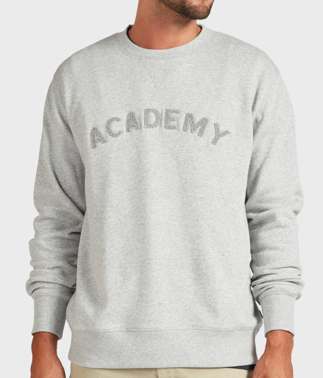 A person wears an Academy Brand College Crew in light gray with "ACADEMY" in large letters across the chest; their head is partially out of frame.