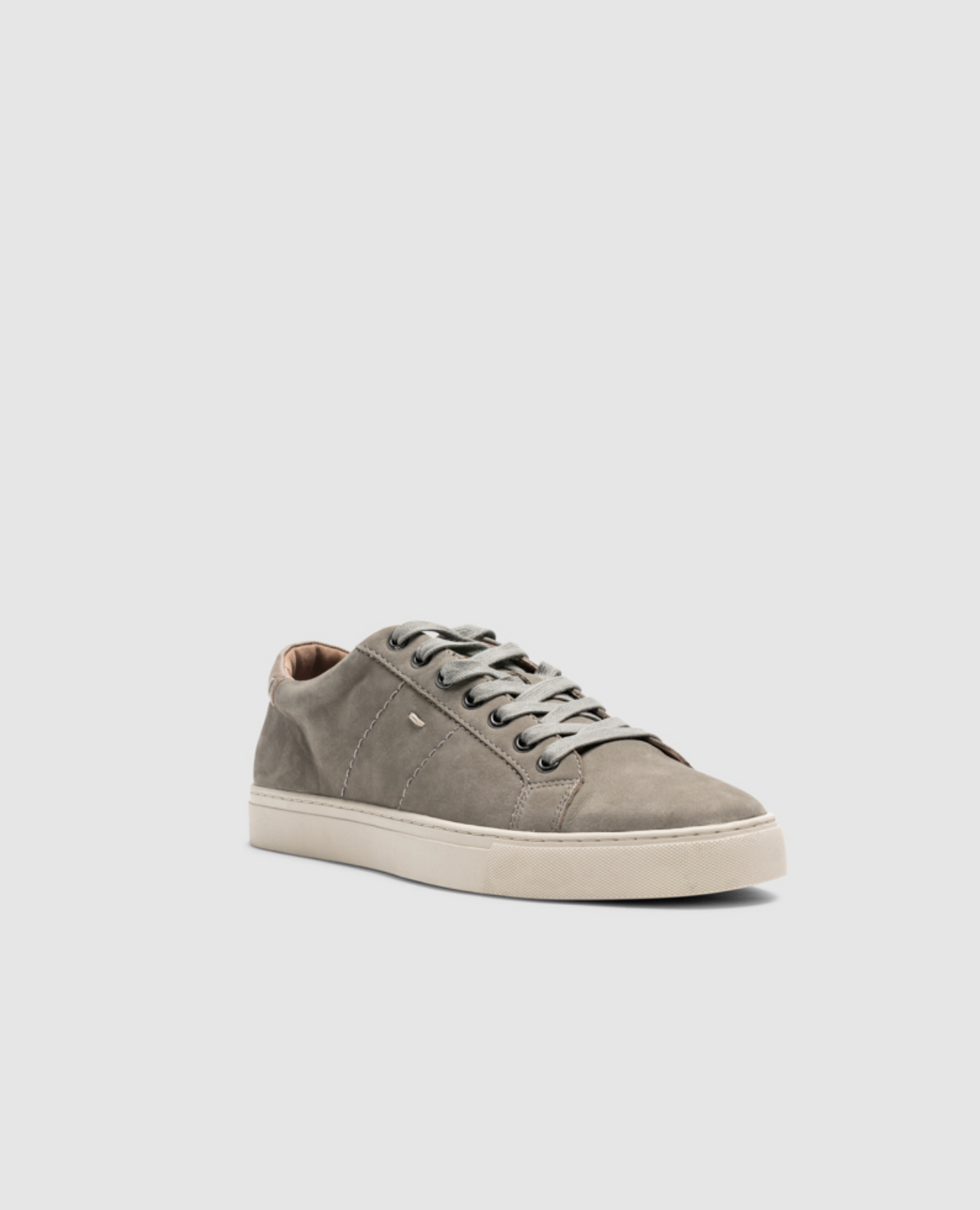 The Rodd & Gunn Endeavour Spirit Sneaker in gray nubuck leather is displayed against a plain white background. Featuring clean lines, matching gray laces, and comfortable white rubber soles, this sneaker offers a minimalistic design for a simple yet stylish appearance.