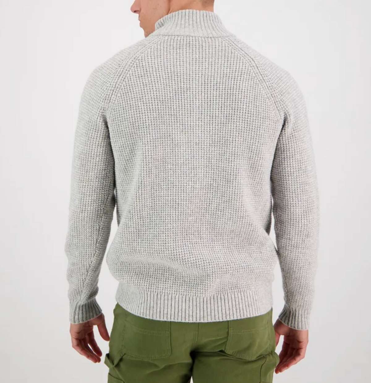 A man faces away, wearing the Swanndri Chalky Island Waffle Jumper in light gray and olive green cargo pants, set against a plain white background.