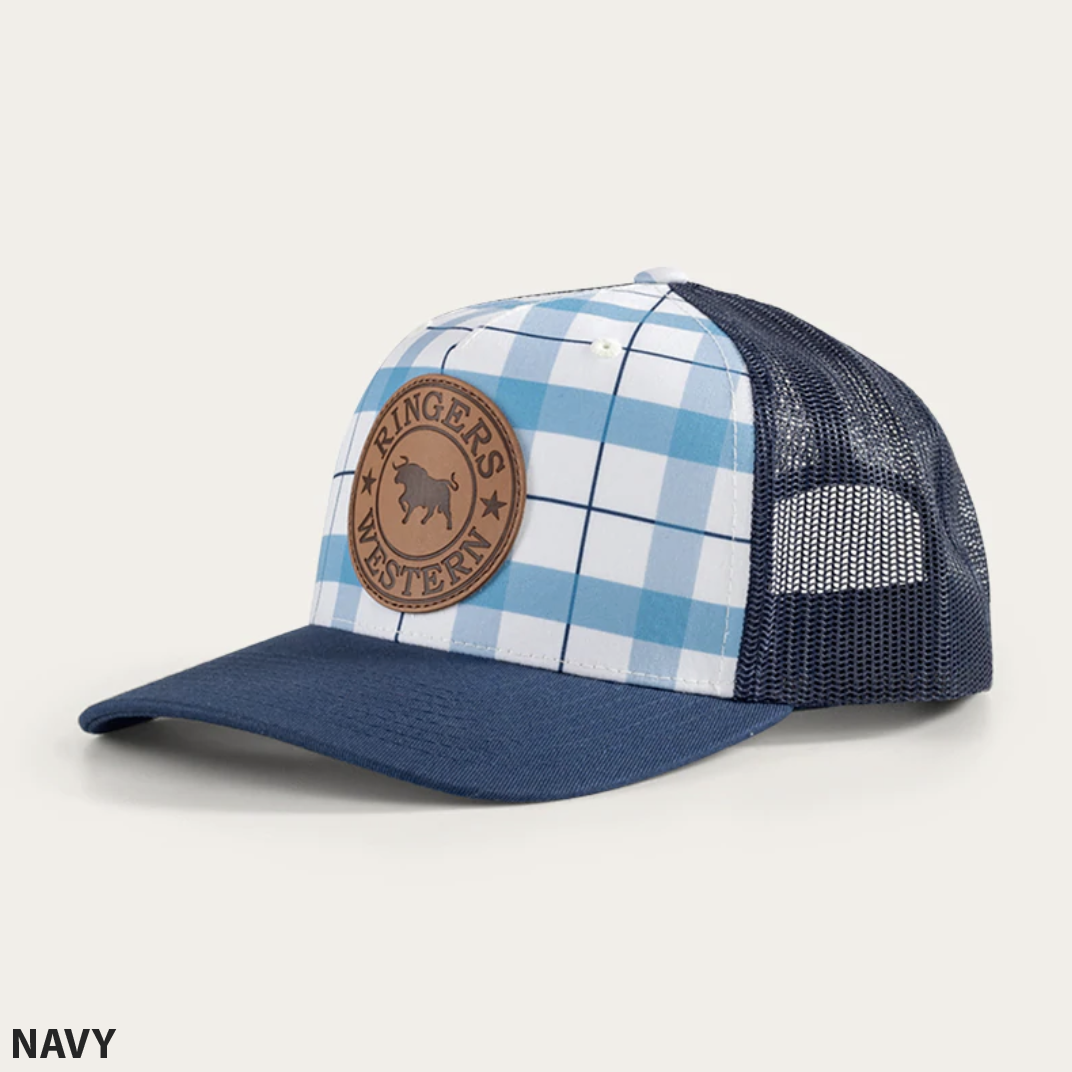 Introducing the Ringers Western Flint Trucker Cap: a navy blue trucker hat with a stylish blue and white checkered front panel. It features a distinctive brown leather patch embossed with a bull and the text "Ringers Western." The back is crafted from navy blue mesh and includes an adjustable strap for the perfect fit. Text in the bottom left corner reads "NAVY.