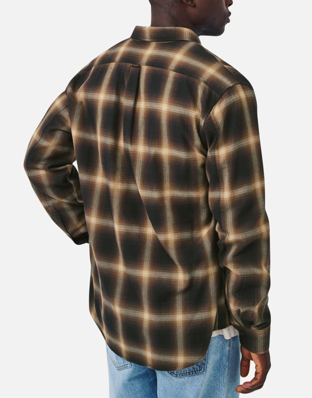 Viewed from the back against a white background, a person wears Industrie The Benson Shirt—a stylish brown and black plaid cotton long-sleeve with a loose, comfortable fit—paired with light blue jeans. They stand with one hand on their hip.