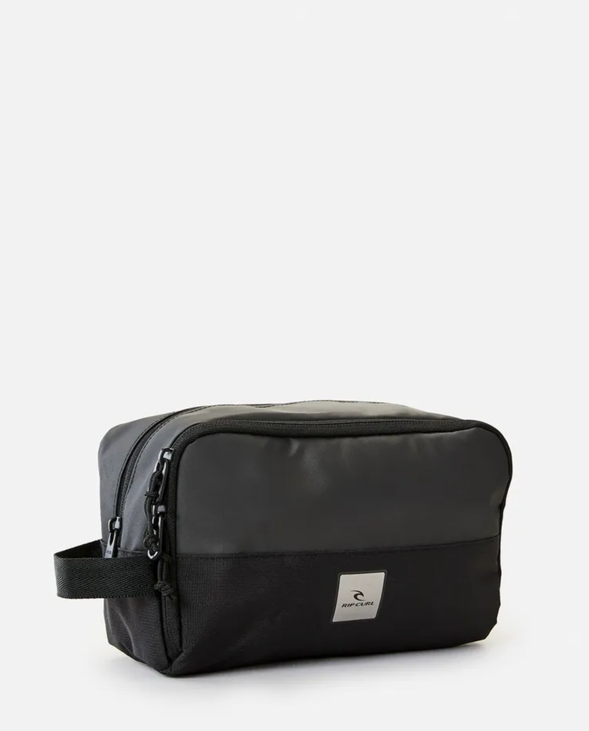 The Rip Curl Groom Toiletry Midnight bag boasts a rectangular shape and is crafted from durable polyester. It features a zipper closure, a carrying handle on one side, and a small rectangular label with the logo on the front. The bag showcases a minimalist design and has a smooth, matte finish.