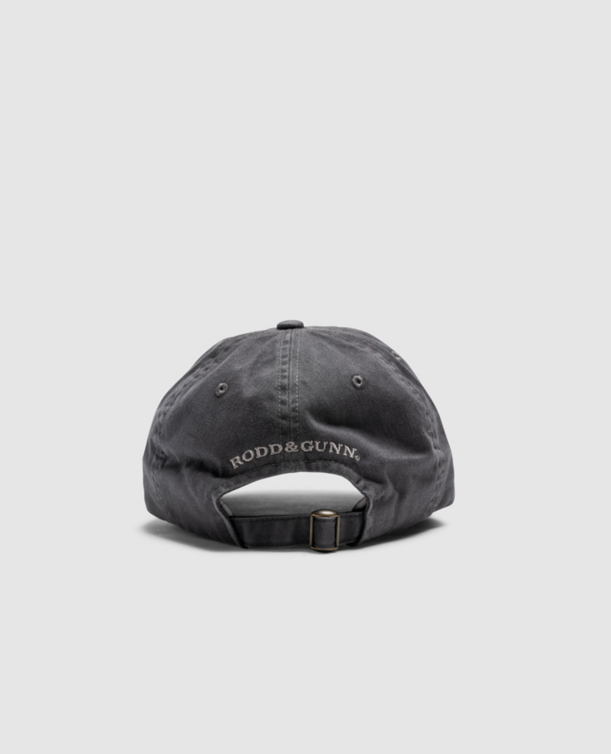 The Rodd & Gunn Double Barrel Cap boasts heavy-duty cotton twill in light gray, with "RODD & GUNN" embroidered elegantly in white on the back and a metal buckle for easy adjustment.