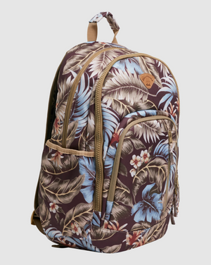 The Billabong Slow Daze Roadie Backpack, crafted from recycled polyester, features a tropical floral print with blue hibiscus flowers and white blossoms accompanied by green and beige leaves. It includes multiple compartments along with tan zippers and straps, making it ideal for any adventure.