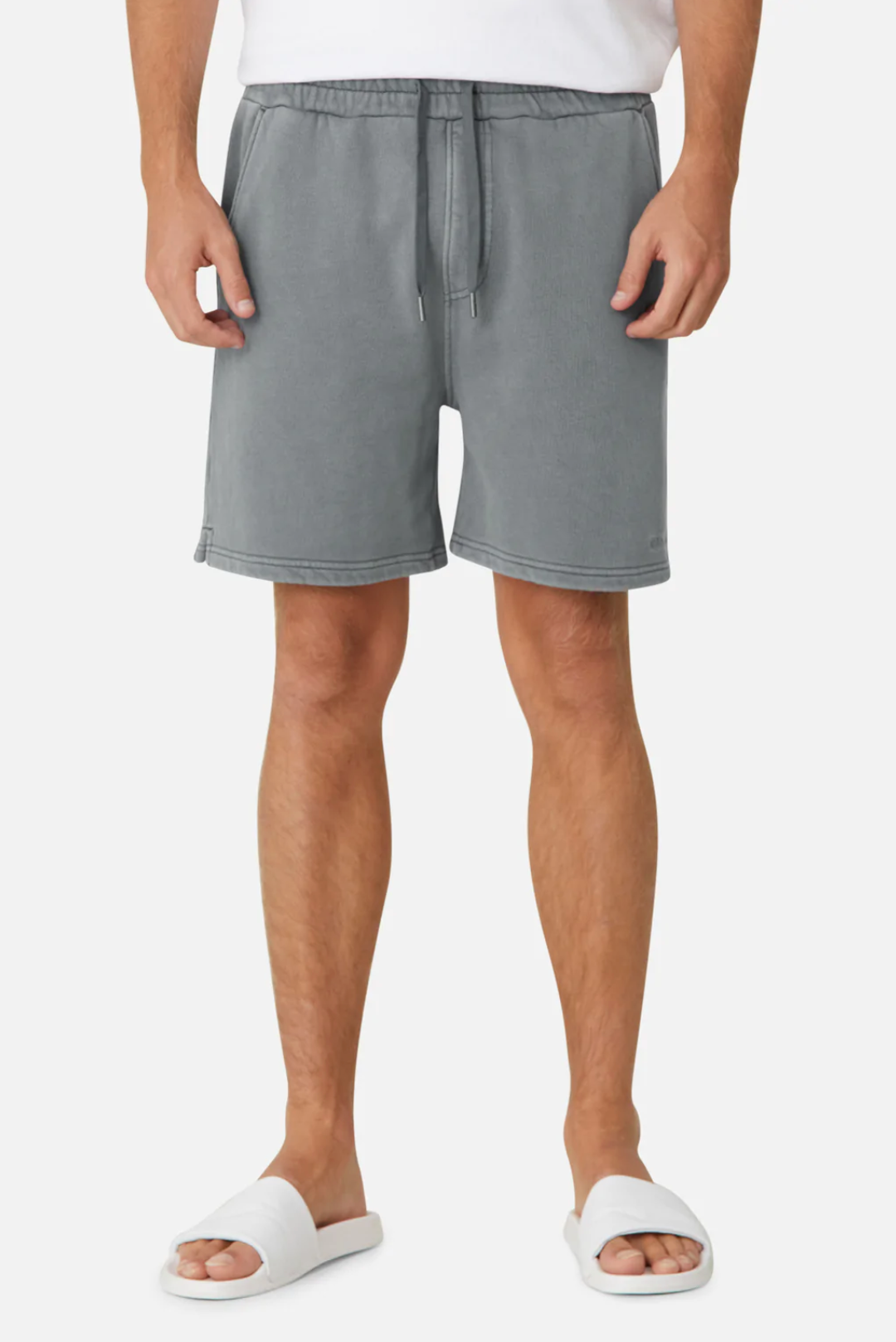 A person is wearing Industrie The Del Sur Track Shorts in gray, which have an adjustable drawstring and elastic waist for a casual oversized fit, along with a white T-shirt and white slide sandals against a plain white background.
