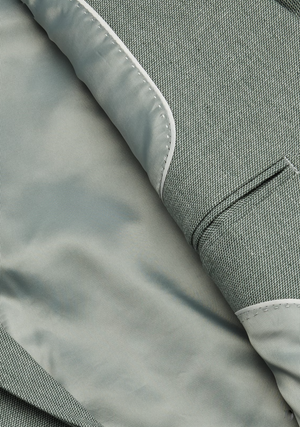 Close-up of the Connor Scarborough Slim Blazer interior, featuring smooth gray lining, a pocket with stitching detail, and a lapel with contrasting textured design.