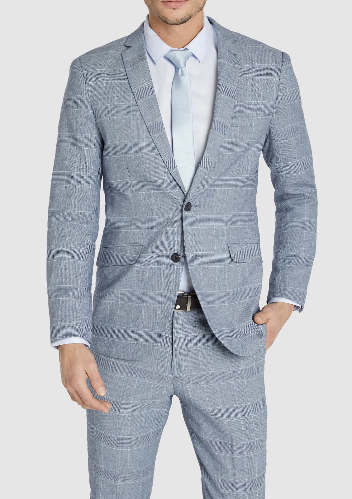 A man wears the Connor Sorrento Slim Suit Jacket in light blue with a white dress shirt and matching tie, standing against a plain background with one hand in his pocket.
