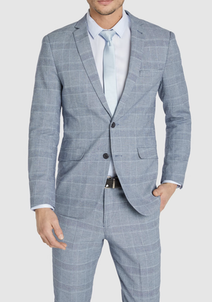 A man wears the Connor Sorrento Slim Suit Jacket in light blue with a white dress shirt and matching tie, standing against a plain background with one hand in his pocket.
