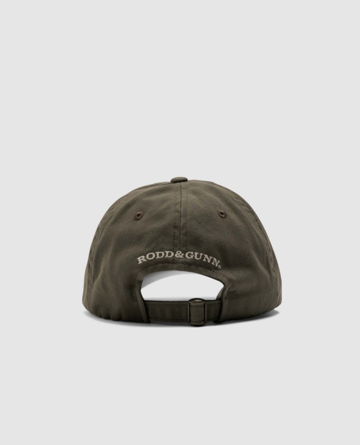 Back view of a dark green Rodd & Gunn Gunn Cap made from heavy-duty cotton twill, featuring a white "RODD & GUNN" logo, with a curved brim and an adjustable fabric strap with a metal buckle, set against a plain gray background.