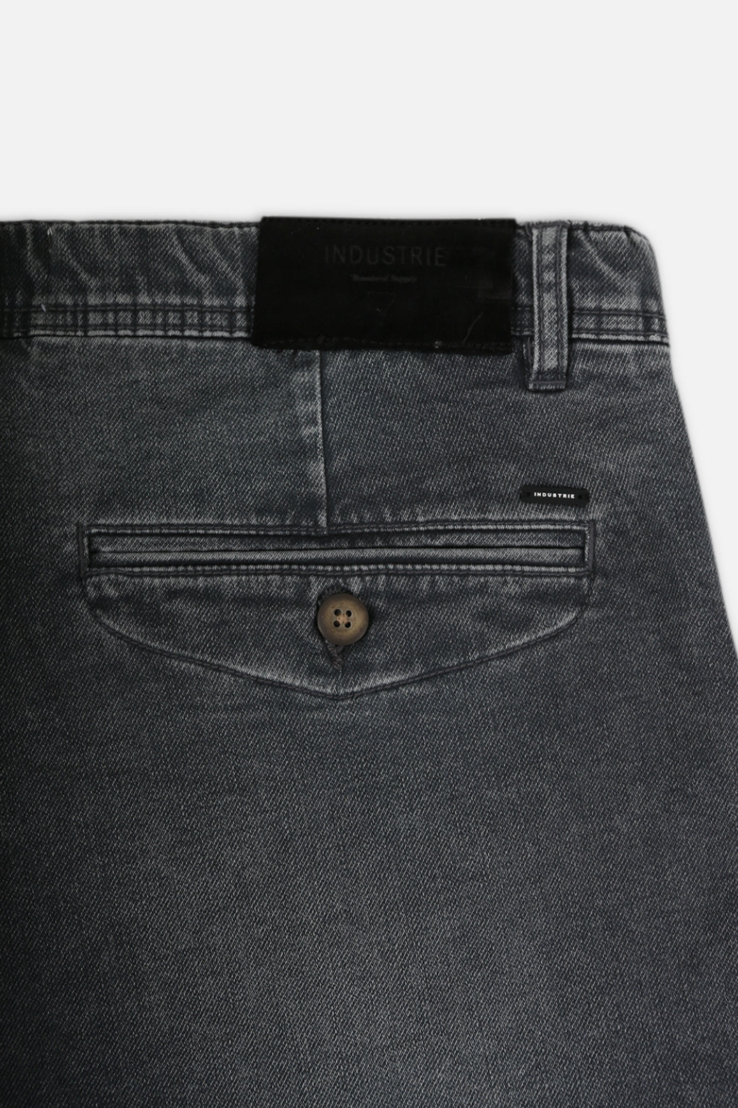 Close-up of dark gray Industrie The Drifter Denim Shorts with a button-closure back pocket. A black "Industrie" label on the waistband adds authenticity, while subtle stitching details elevate these comfortable shorts beyond expectations for fans of Industrie shorts.