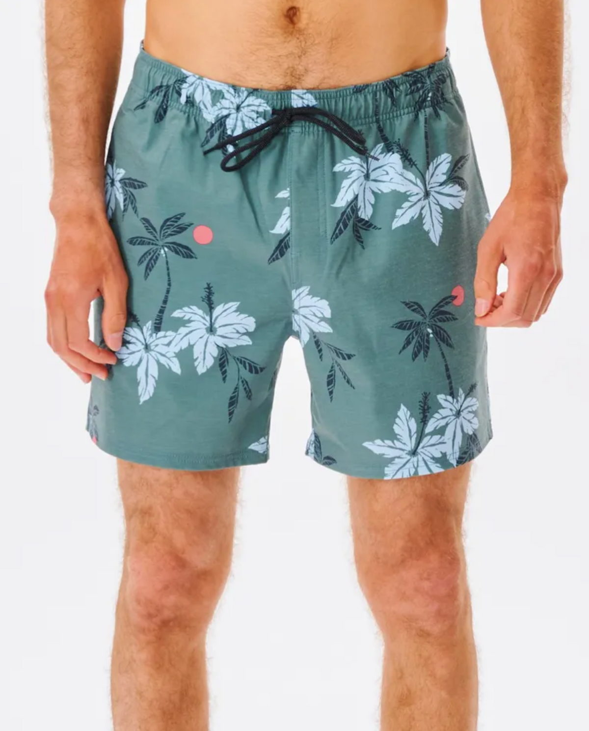 A shirtless person is seen wearing green Rip Curl Sumatra Volley Shorts with a black drawstring, decorated with white palm trees and small orange circles, made from quick-dry recycled fabric, highlighting only their torso and legs.