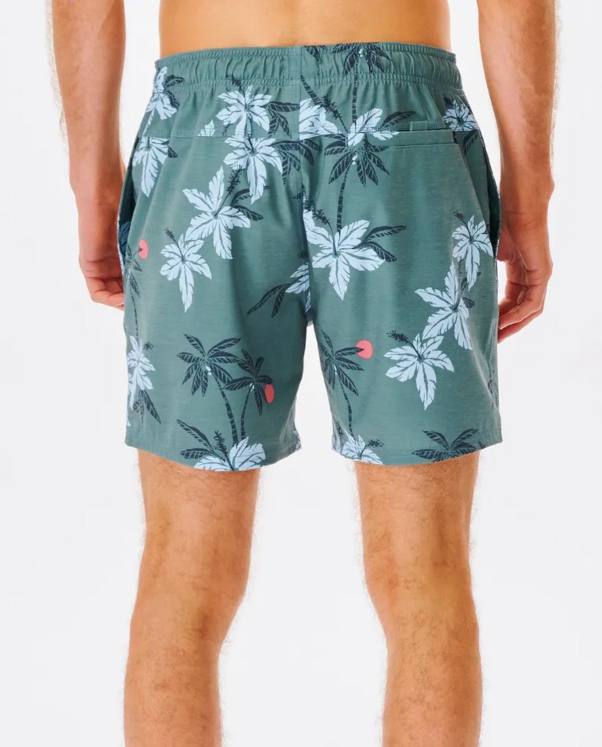 A person is seen from the back wearing Rip Curl Sumatra Volley Shorts, featuring a green base with white palm trees and small red circles. Made from quick-dry fabric, these shorts include an elastic waistband and pockets. The backdrop is a plain white background.