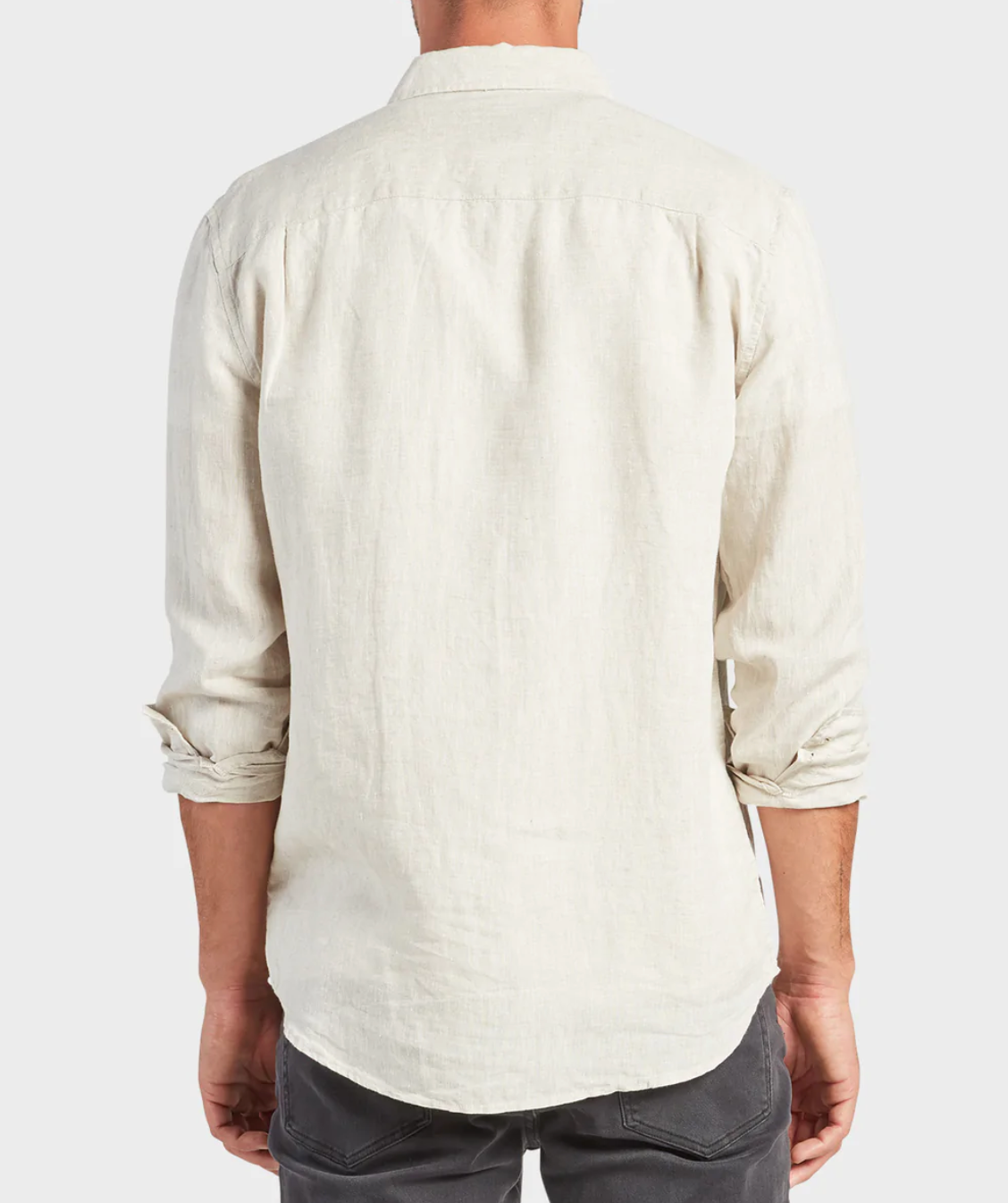 Rear view of a person in the Academy Brand Hampton Linen Shirt, light beige with sleeves rolled up, paired with dark gray pants. The regular fit exudes effortless style against a plain white background.