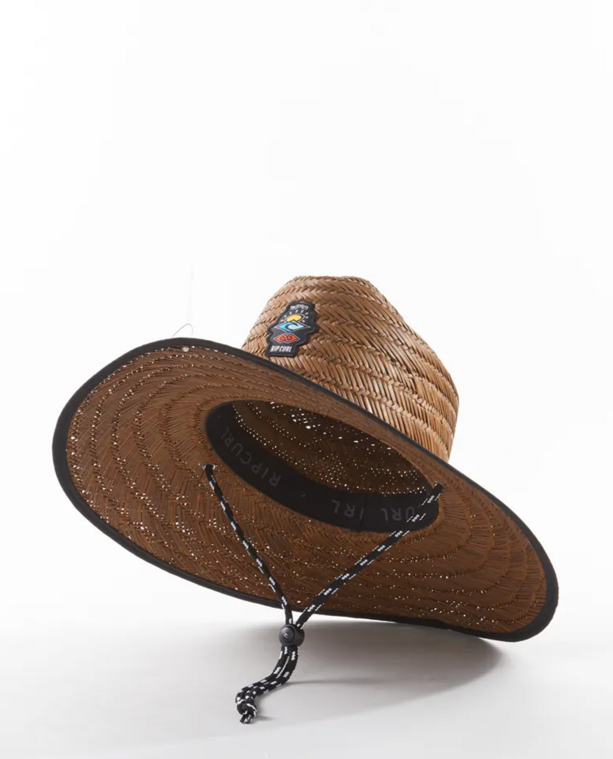 The Rip Curl Icons Straw Hat has a wide brim, black trim, chin strap, and a vibrant embroidered front patch, shown on a plain white background.