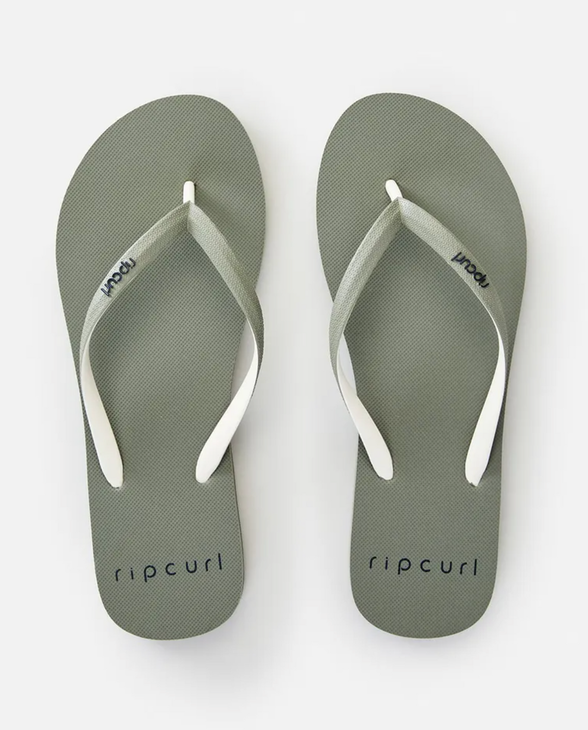 A pair of Rip Curl Bondi 2 Tone Thongs in green with white straps. The word "ripcurl" is printed on each sole near the toes and also on the straps. Made of durable thermo rubber compound, these summer thongs are placed side by side on a plain white background.