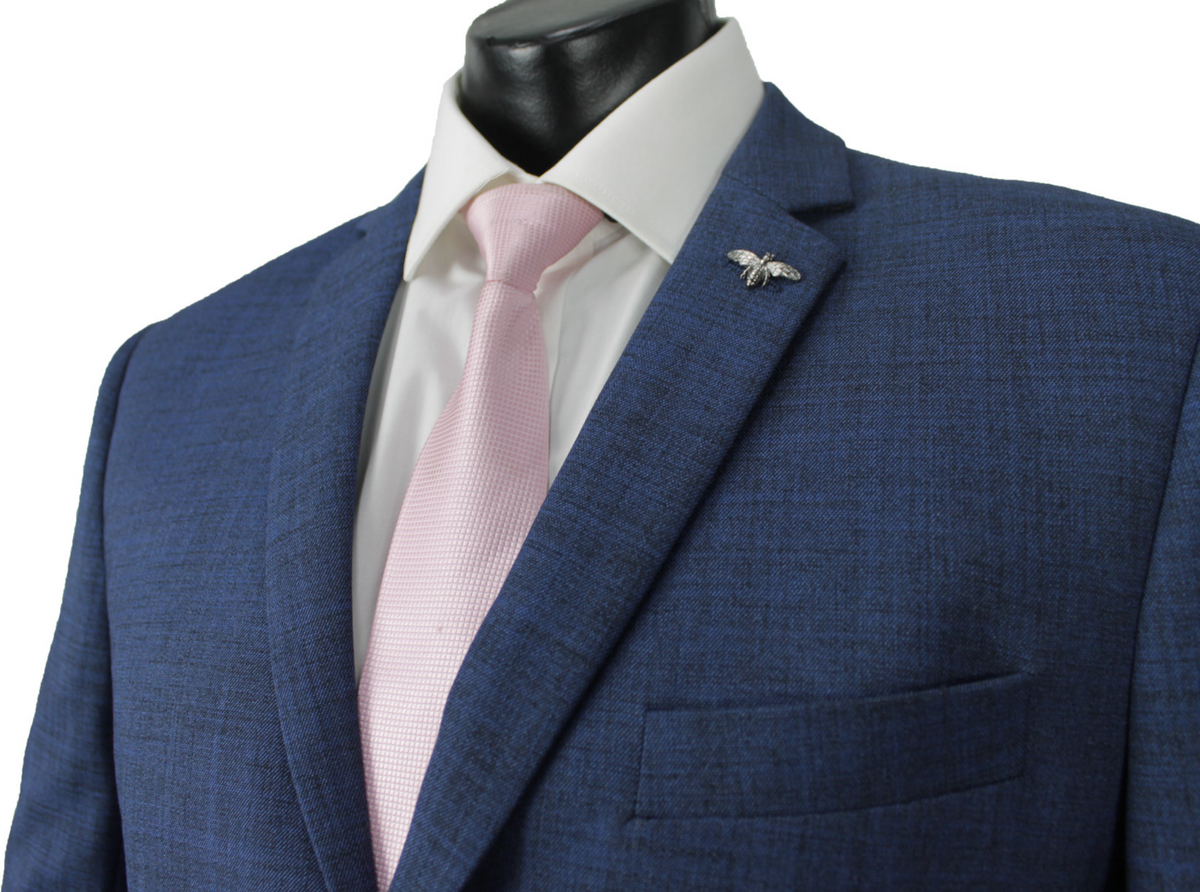 A mannequin showcases the Scuzzatti Slim Fit Suit with a blue jacket, white dress shirt, and pink tie. A silver bee lapel pin adds elegance. For a perfect fit, refer to our size guide or half chest measurement for top-notch customer service.