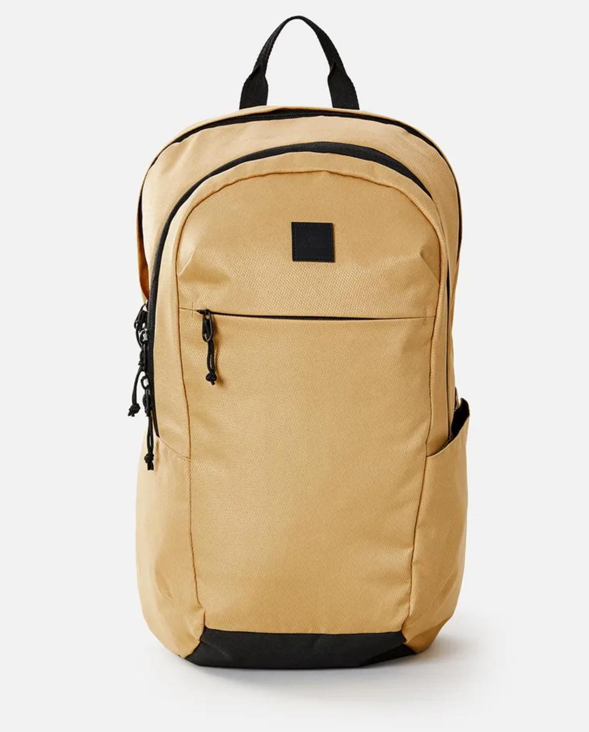 The Rip Curl Overtime 30L Overland Backpack in beige is made from recycled polyester and has black zippers, a small front pocket, side pockets, and a sturdy black top handle. It fits a 15" laptop securely with multiple zippered compartments against a white backdrop.