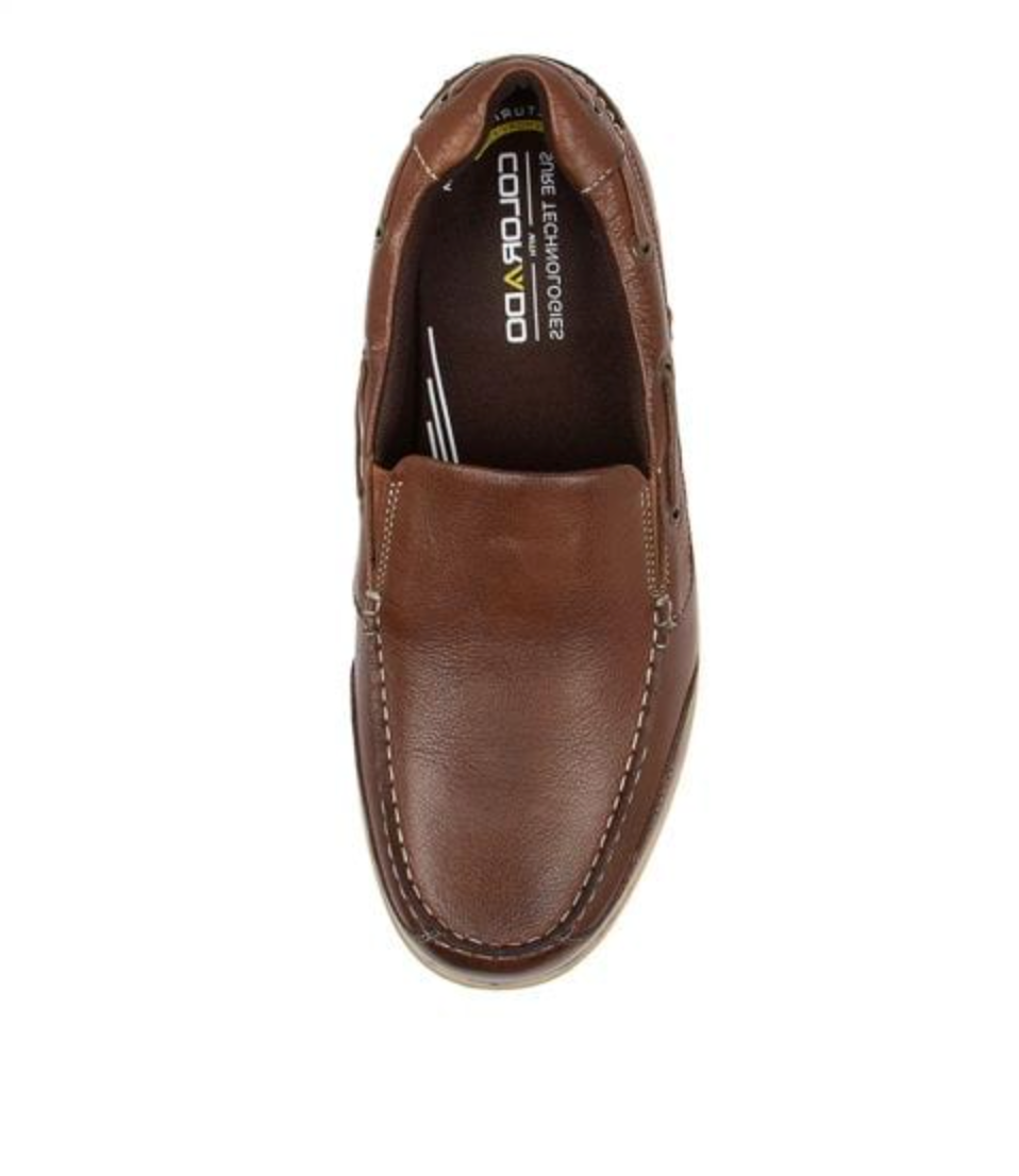 Top view of a Colorado Broad Slip On Boat Shoe in brown leather with white stitching, slip-on design, and brand text on the insole. It features a memory foam footbed for added comfort, displayed on a plain white background.
