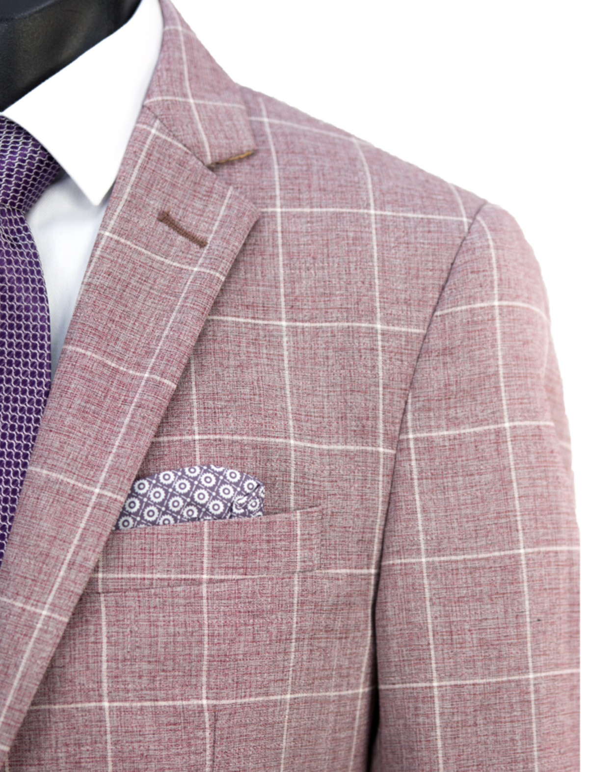A close-up of a mannequin features the Scuzzatti Check Suit, a slim-fit pink plaid wool-blend jacket with white grid lines, paired with a purple patterned pocket square, all enhanced by a white shirt and textured purple tie, exuding elegance and style.