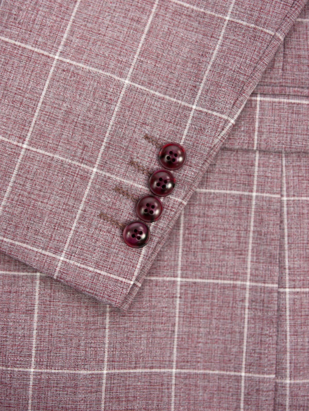 Close-up of the Scuzzatti Check Suit sleeve, crafted from a red checkered wool blend fabric. It features four burgundy buttons in a neat row and displays thin white lines forming a grid-like pattern.