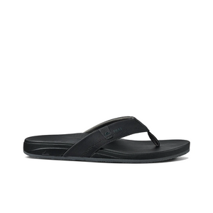 The REEF Cushion Spring is a black flip-flop sandal featuring thick synthetic leather straps, subtle stitching, a small logo on the strap, and a textured sole. Its minimalistic design offers casual style and essential arch support for enhanced comfort.