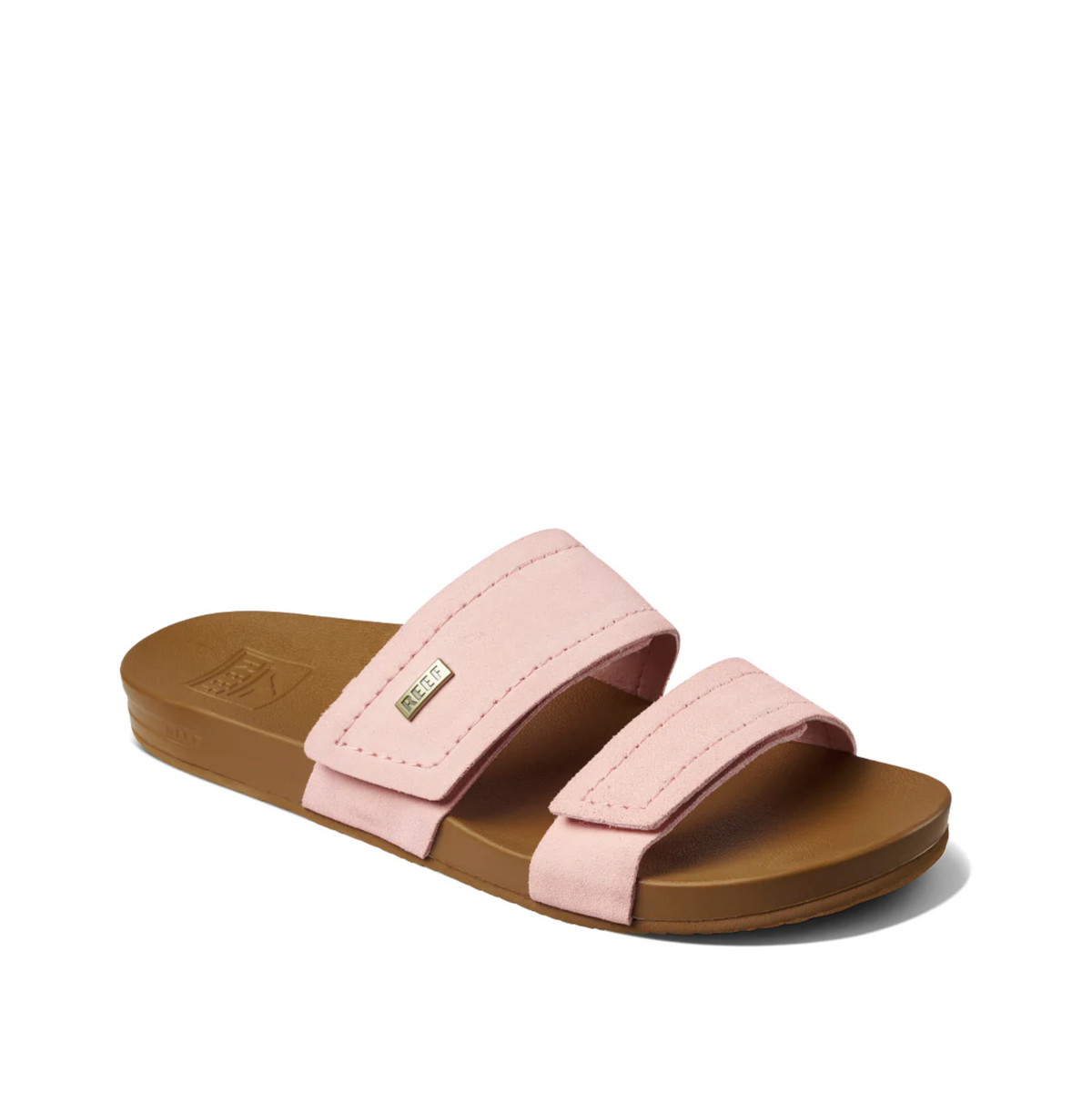 The REEF Velcro Vista SE pink slide sandal showcases premium leather straps and two adjustable bands over a brown sole, including a small brand label on the top strap. It features a cushion bounce midsole for added comfort.