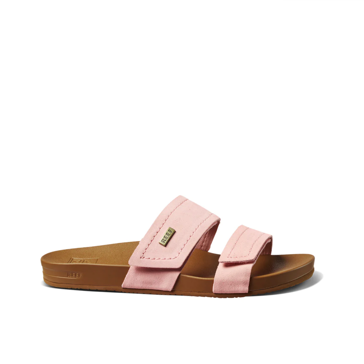 The REEF Velcro Vista SE sandals feature a brown sole and two pink premium leather straps with small metallic branding tags. Designed with a cushion bounce midsole, they offer a flat base ideal for casual wear.