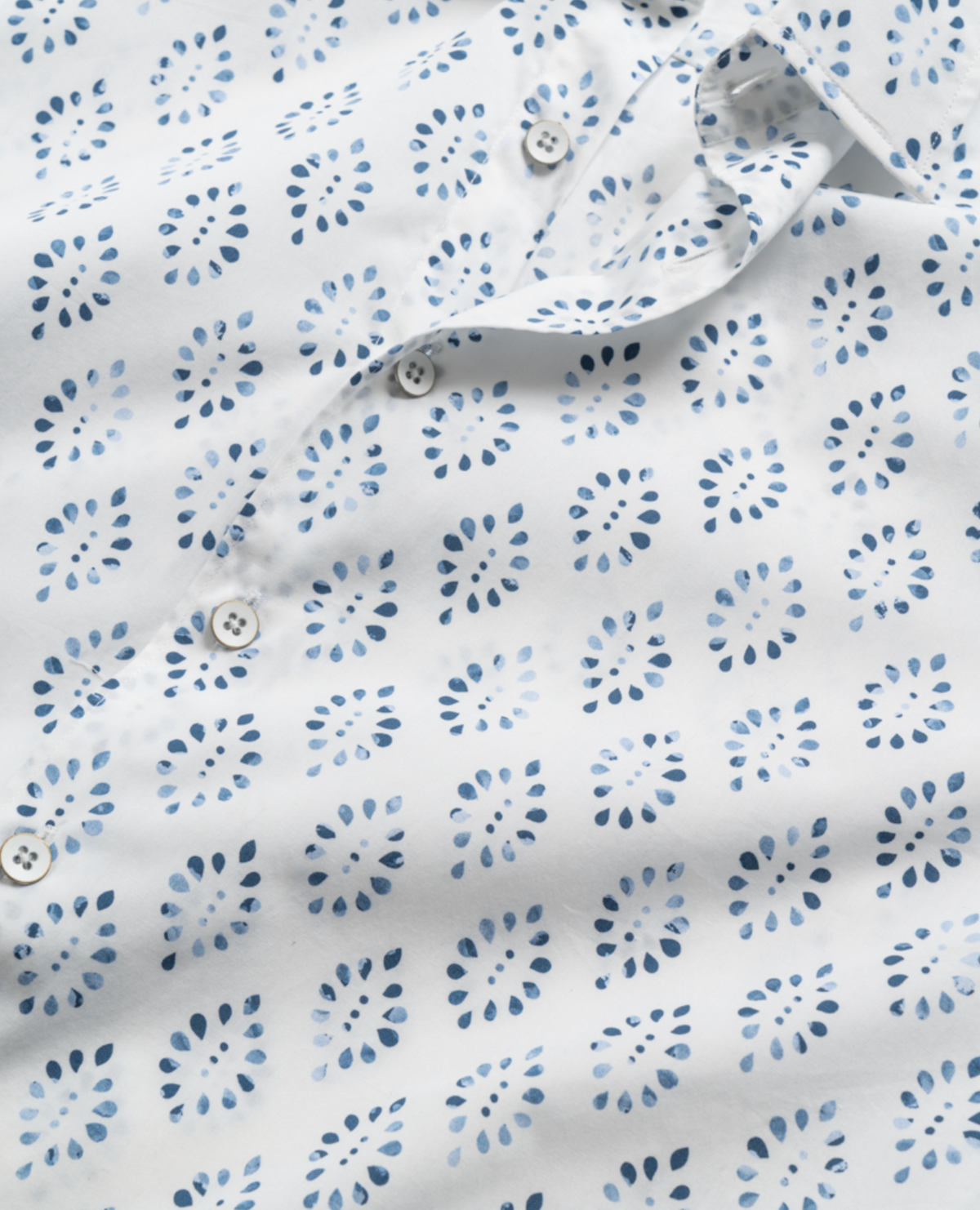 Close-up of a Rodd & Gunn Penguin Place Sports Fit Shirt showcasing blue dot clusters in a grid pattern on 100% cotton fabric. It features small white buttons down the front.