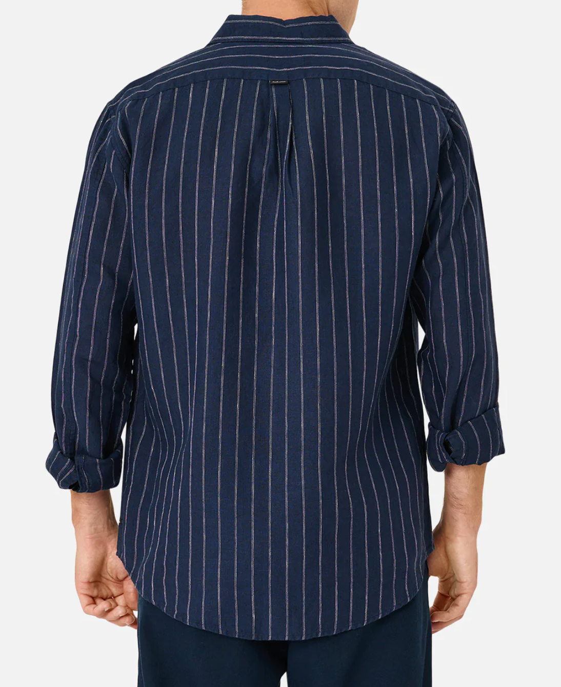 A person is wearing Industrie The Giacomo Linen Shirt, a long-sleeved, dark blue linen shirt with vertical white stripes in a classic fit. The rolled-up sleeves and untucked style create an understated look as only the back is visible against a plain white background.