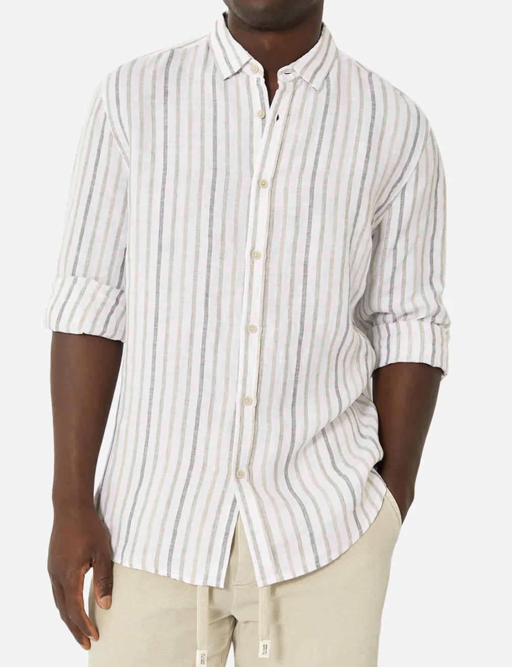 A person stands against a plain background wearing the Industrie The Webster Long Sleeve Shirt, featuring a relaxed fit with white and gray vertical stripes. They have one hand in their pocket, light pants, and rolled-up sleeves that convey ease and sophistication.