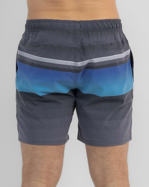 A person wears Rip Curl Party Pack Volley Shorts featuring a blue and gray gradient and elastic waistband, standing against a plain light background with only their torso and legs visible.