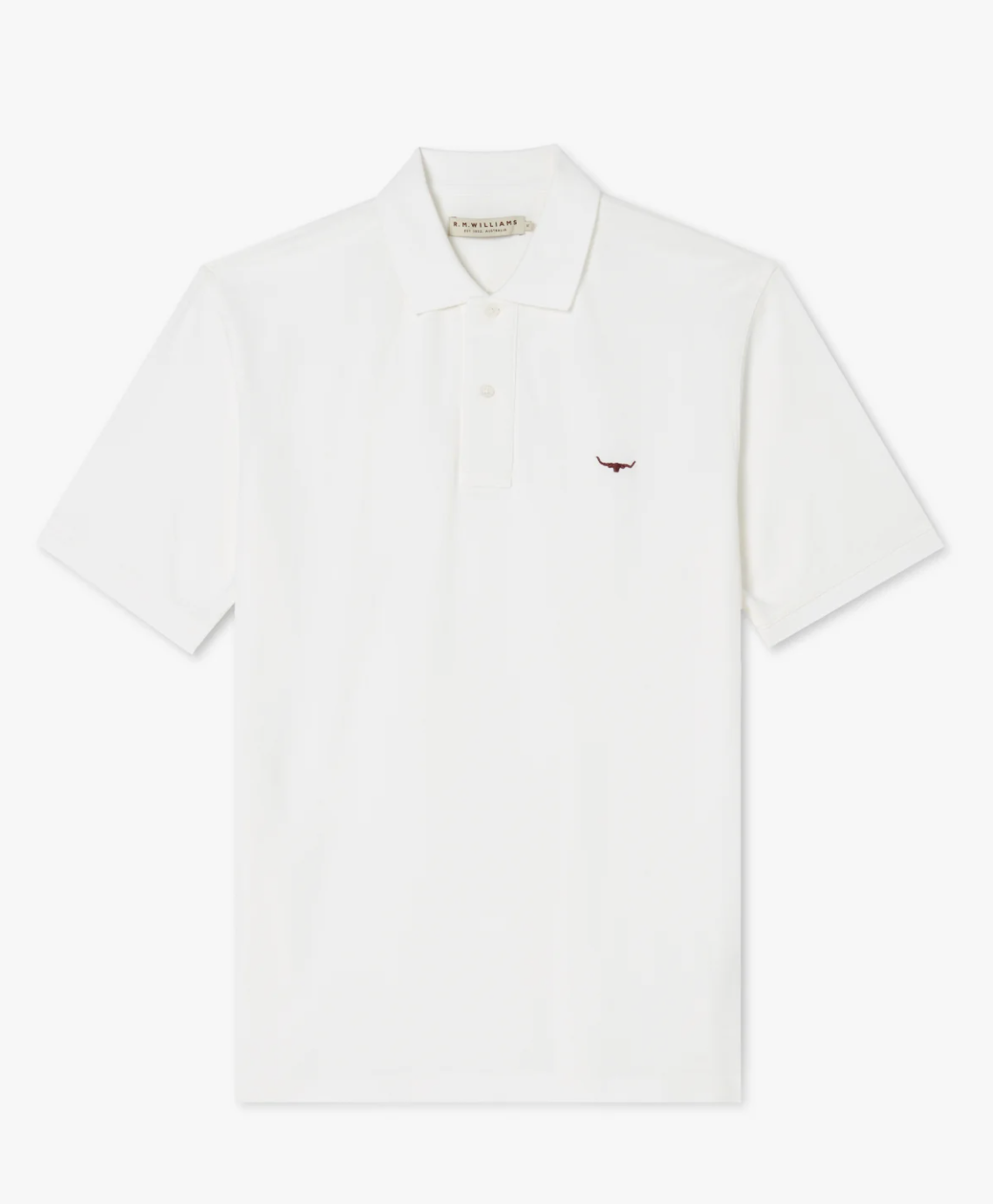 The RM Williams Rod Polo is a plain white cotton shirt featuring a collar and three buttons. A small embroidered logo resembling a red bull's head adorns the left chest area, making it a casual wardrobe staple.