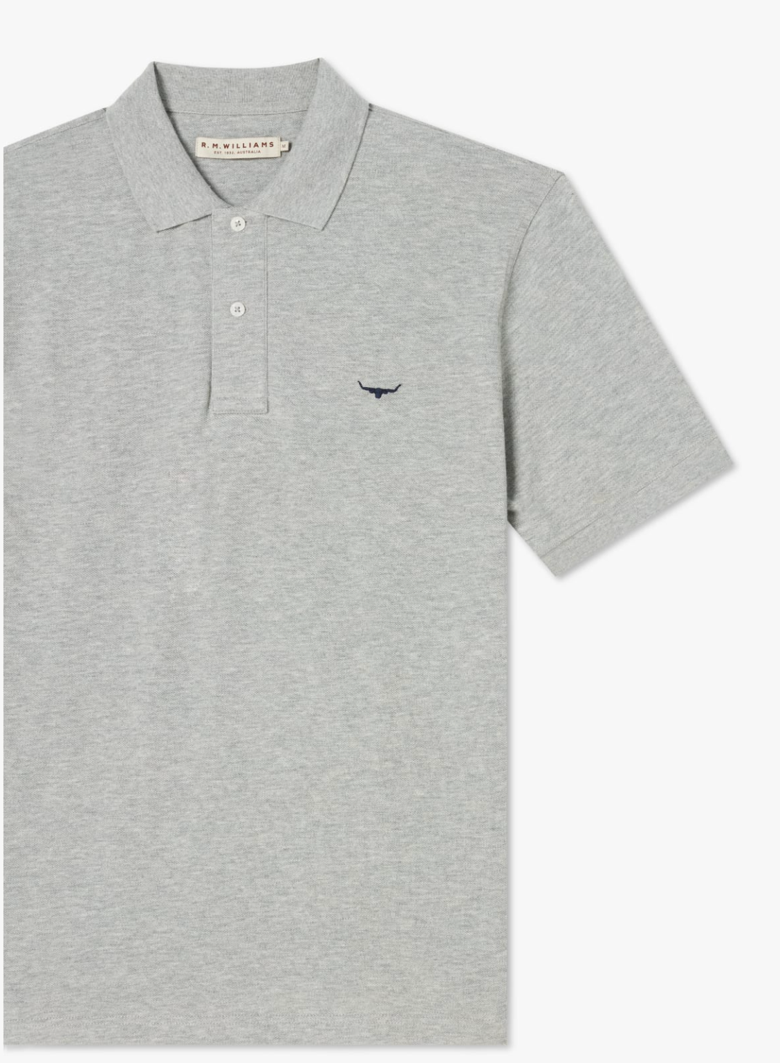 The RM Williams Rod Polo is a gray cotton shirt with short sleeves, a ribbed collar, and a three-button placket. It features a small embroidered longhorn logo on the left chest.