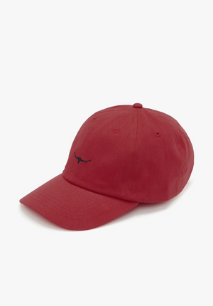 The RM Williams Mini Longhorn Cap in red showcases a small black longhorn logo on the front. This classic twill cap features a curved brim and six-panel construction, complete with a button on top and ventilation holes. It is displayed against a plain white background.