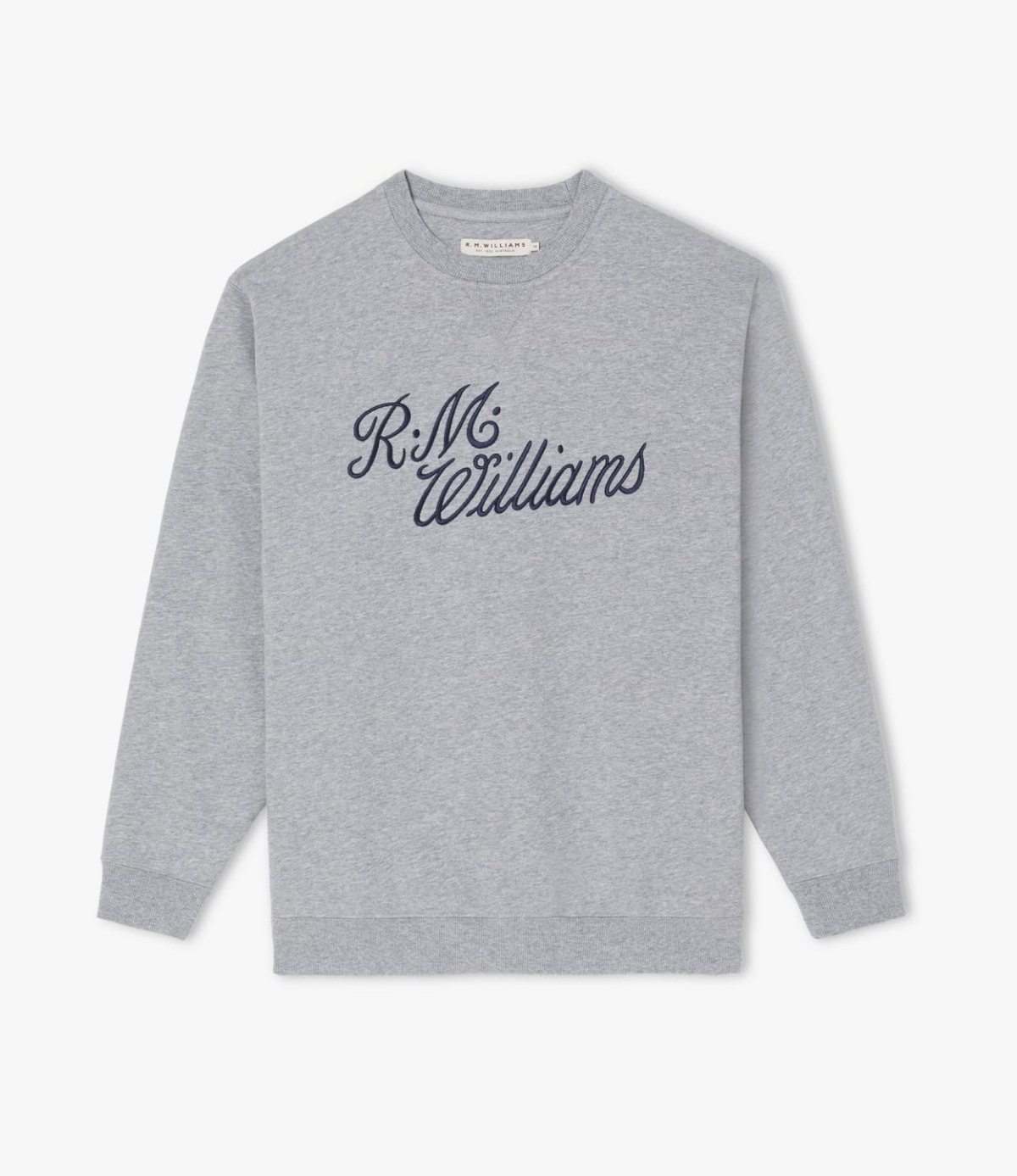 The RM Williams Script Crew Neck is a light grey jumper showcasing navy blue script logo embroidery that spells out "R.M. Williams" across the chest. Crafted from a cozy cotton-blend fleece, this sweatshirt features a classic crew neck design along with ribbed cuffs and hem.