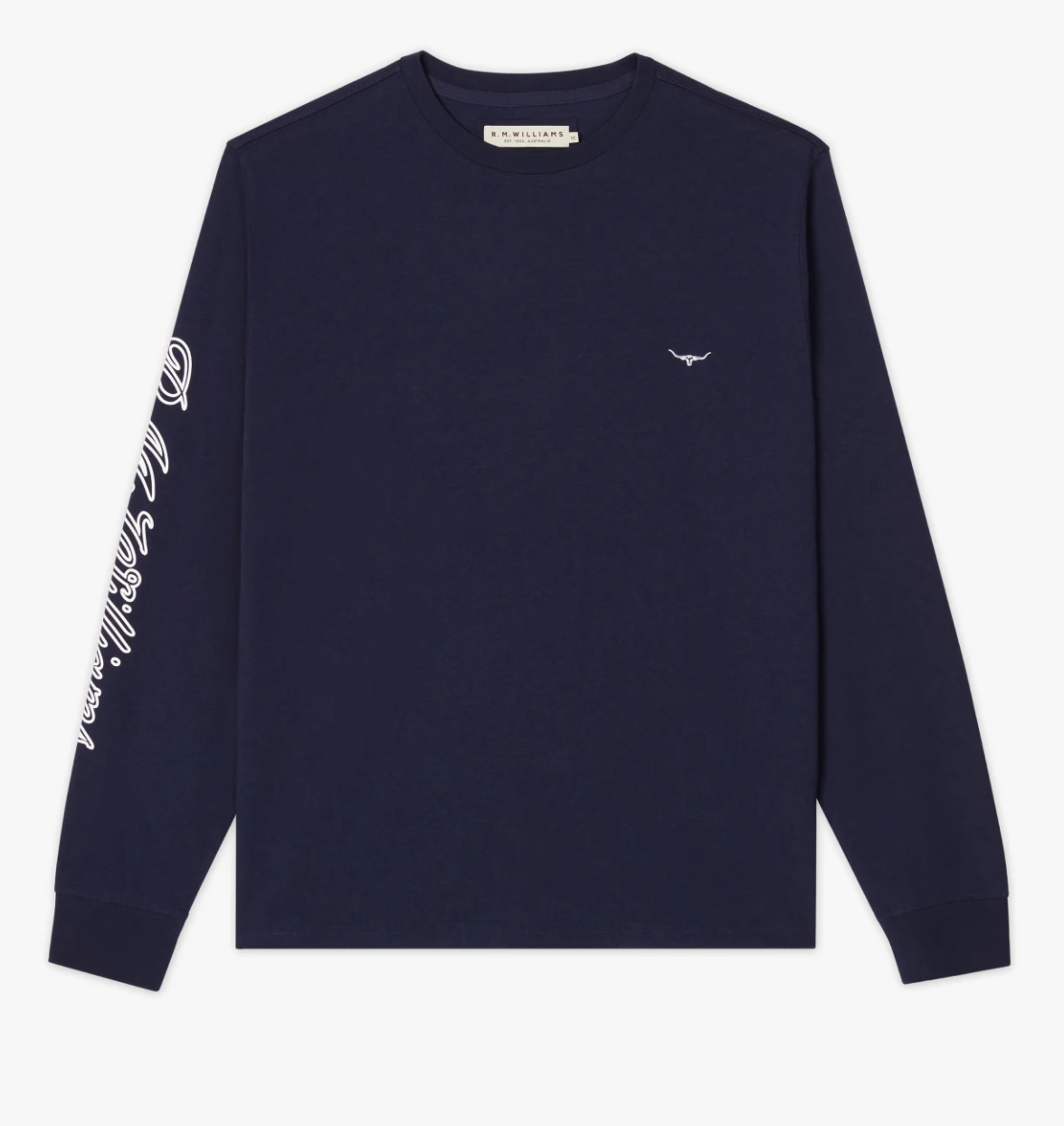 The RM Williams Signature Long Sleeve T-Shirt is a navy blue, long-sleeved shirt featuring a small white Signature Longhorn logo on the left chest and script text on the right sleeve. The text on the upper left inside of the collar reads 'R.M.Williams.'