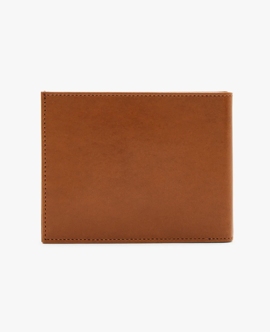The RM Williams Singleton Bi-fold Wallet, crafted from brown calf leather with a smooth minimalist design, is displayed against a white background. The closed wallet showcases elegant craftsmanship and offers RFID protection.