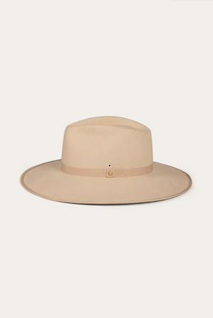 The Ringers Western Woodford Hat is a beige wide-brimmed fedora made from premium felt, with a matching grosgrain ribbon and small buckle, radiating its charm against a plain white background.