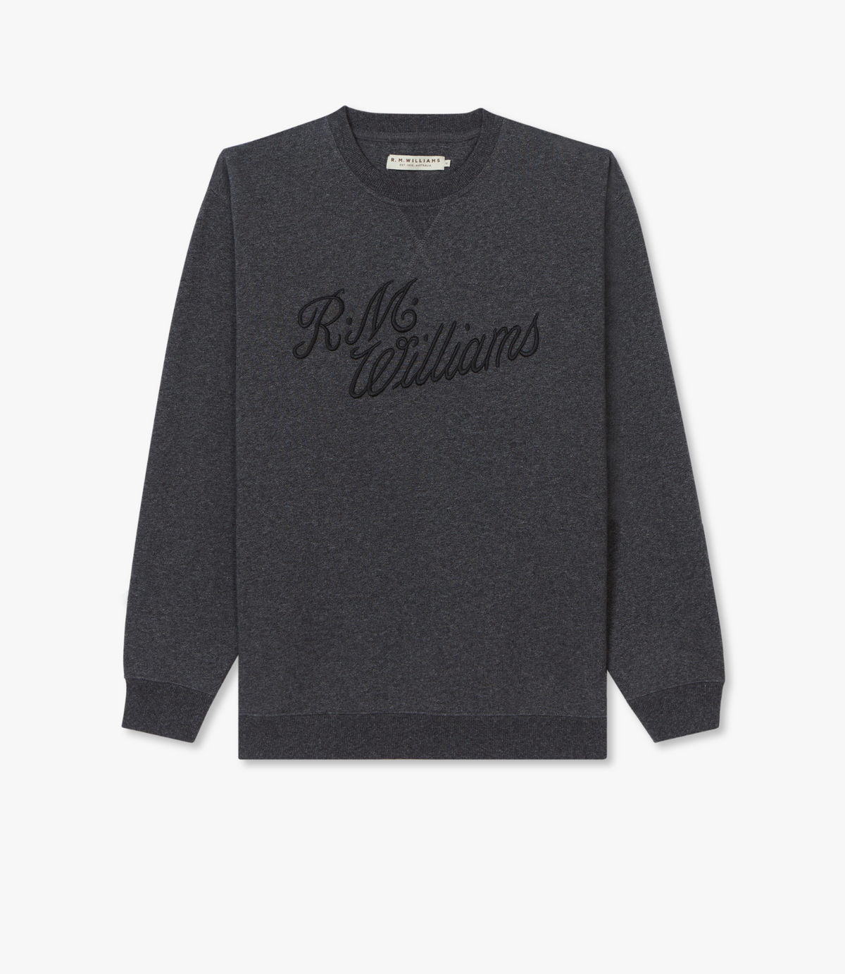 The RM Williams Script Crew Neck is a dark grey cotton blend jumper with ribbed cuffs and hem, featuring "R.M. Williams" embroidered in black cursive on the front.