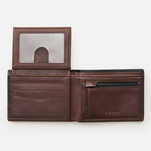 The Rip Curl Ridge PU All Day Wallet, made from rich brown leather with a textured surface, includes multiple card slots, a transparent ID window, and a zippered coin pocket. Laid flat on a white background, it highlights sleek design and functionality.