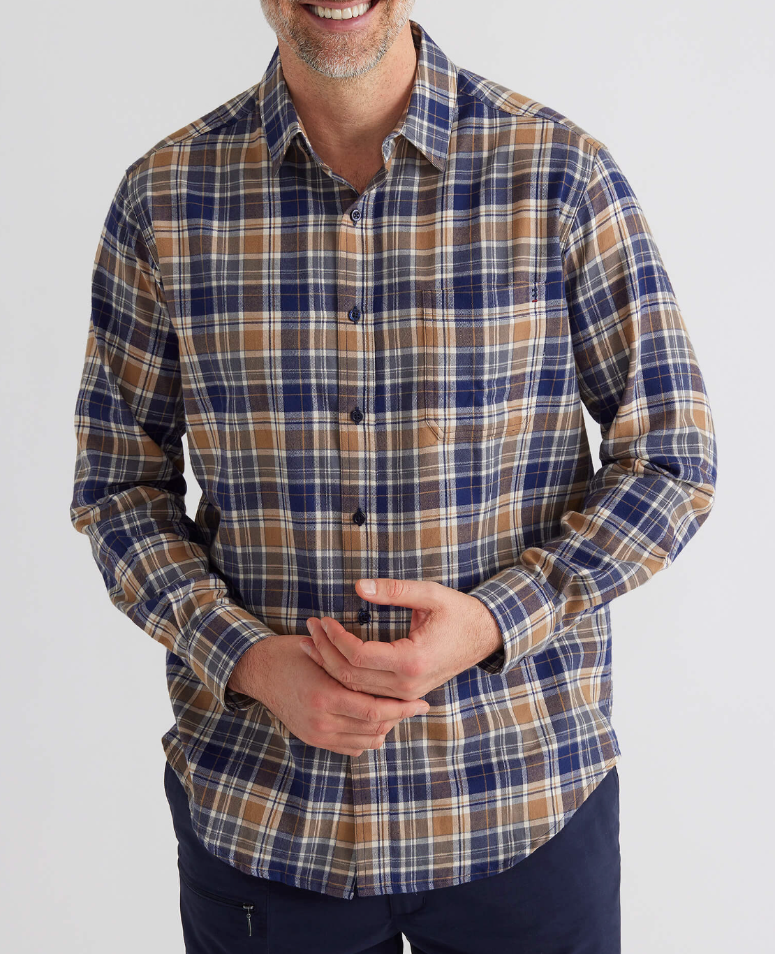A person dons the Breakaway Ford Cotton Brush Shirt, an easygoing plaid design in blue, brown, and white against a plain white backdrop. This 100% cotton, long-sleeved, button-up shirt has one hand on their waist, combining style with comfort for any casual breakaway moment.