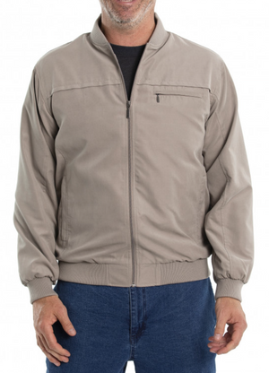 A person wearing a Breakaway Microfibre Bomber Jacket in light brown over a dark shirt and blue jeans, stands relaxed with hands at their sides. The jacket features ribbed cuffs, zippered pockets, and a small chest pocket.