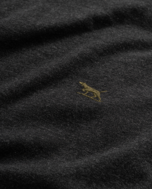 A close-up of the Rodd & Gunn Long Sleeve Gunn T-Shirt in dark, 100% cotton fabric with a small embroidered yellow dog design, features a sports fit texture that is soft and slightly fuzzy.
