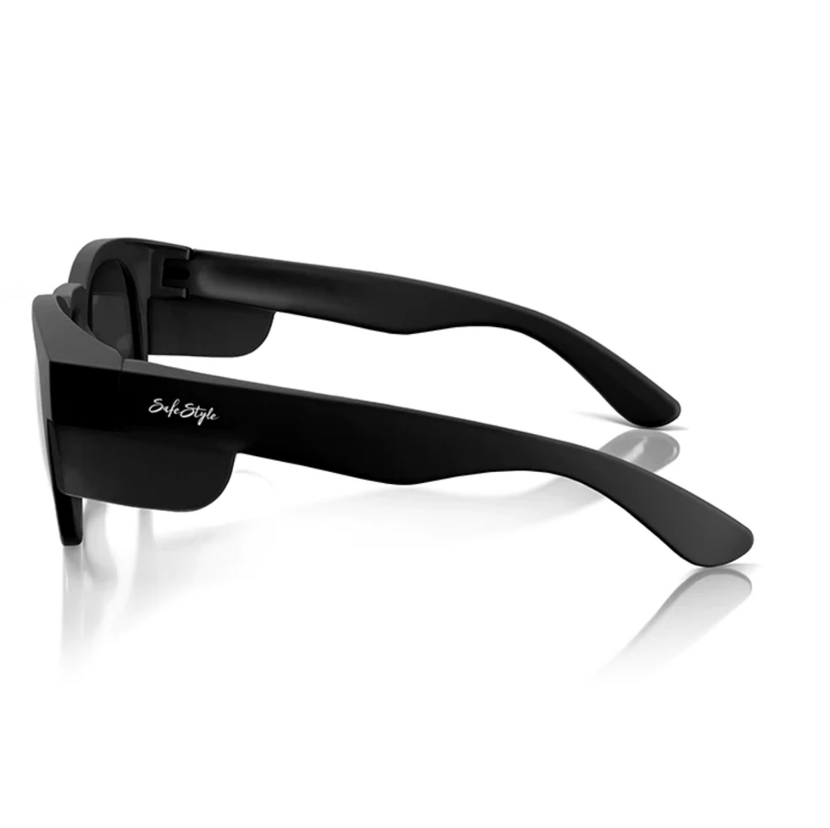 A pair of SafeStyle Cruisers Matte Black Frame Polarised Lens sunglasses with thick frames and slightly curved temples is pictured. Featuring UV protection, the brand name is subtly inscribed on the arms in white text. The sunglasses rest on a reflective surface, showing clarity in their design.