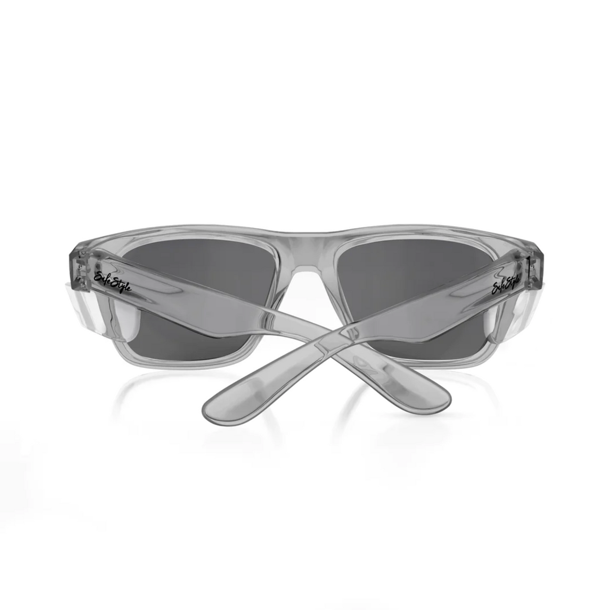 The image showcases the SafeStyle Fusions Graphite Frame Tinted Lens sunglasses from a rear perspective. These sunglasses feature a transparent design with graphite frames and crossed temples, highlighting the brand's logo on both sides. They are equipped with dark rectangular tinted lenses that provide UV protection.