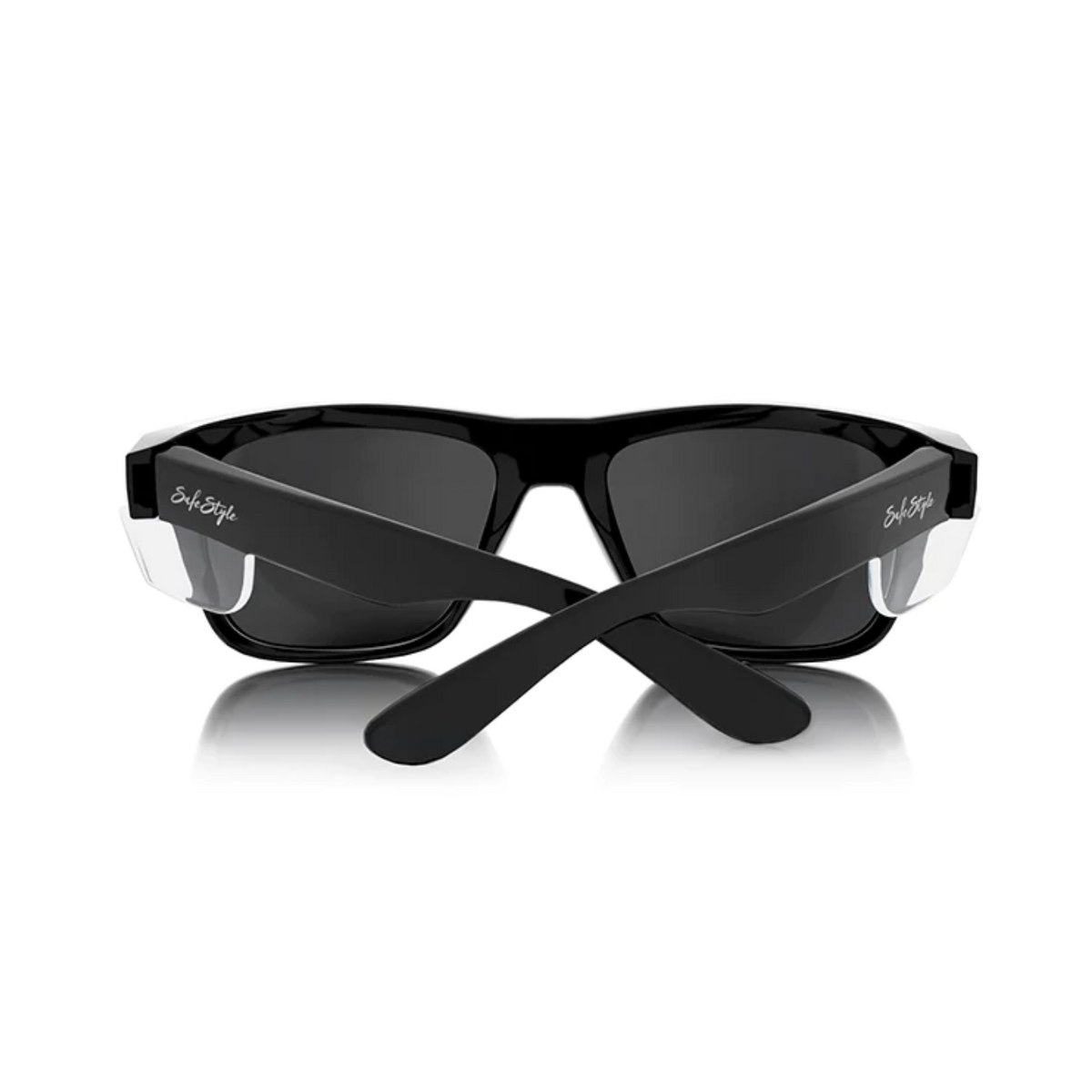 The SafeStyle Fusions feature a sleek black frame with tinted lenses and crossed arms. Silver accents embellish the design, and the brand name is subtly engraved on the side. They provide UV protection for sunny days.